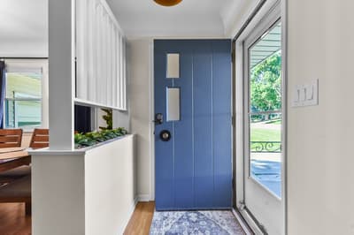A welcoming entrance with striking blue door opens to reveal your stylishly designed interior space.