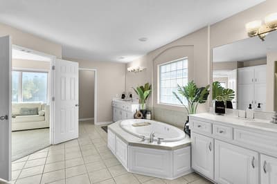 Unwind in your luxurious ensuite with a jetted soaking tub, dual vanities, and serene garden views through the arched window.