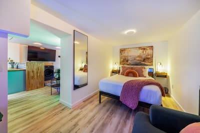Unwind in your stylish bedroom with colorful LED lighting, cozy bedding, and modern amenities creating the perfect retreat.
