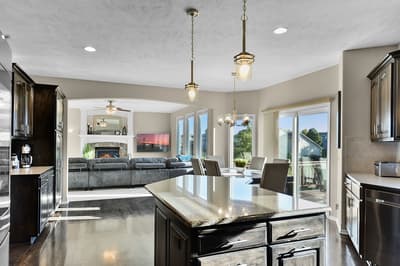 Your gourmet kitchen features granite countertops and premium appliances, seamlessly flowing into the cozy living space with fireplace.