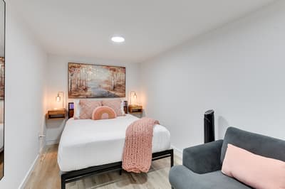 Sink into crisp linens and cozy textures in your peaceful retreat, where warm lighting and thoughtful decor create the perfect sanctuary.