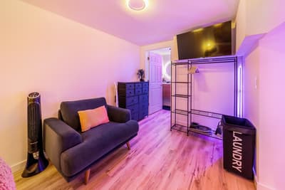 Unwind in your stylish living space with comfortable seating, entertainment, and thoughtful amenities bathed in ambient lighting.