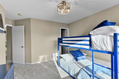 Your children will love this bright bunk bed room with soft linens and nautical lighting for cozy nights.