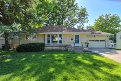 Charming single-story home nestled in a tree-lined neighborhood with convenient driveway parking and welcoming front entrance.