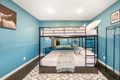 Sleep soundly in your stylish room featuring a unique bunk bed setup with calming blue walls and cozy southwestern decor.