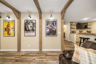 Sink into comfortable leather seating and enjoy movie nights in your stylish entertainment space, complete with rustic beams and curated film posters.