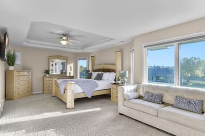 Relax in your spacious master suite with plush seating, modern furnishings, and stunning natural light streaming through oversized windows.