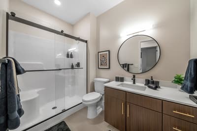 Step into your sleek bathroom featuring a spacious walk-in shower, modern vanity, and thoughtful touches that make your daily routine feel luxurious.
