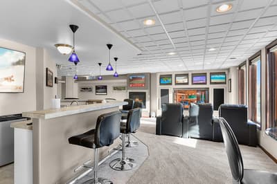 Gather with friends at your private bar featuring premium seating, fireplace warmth, and multiple TVs for the perfect entertainment experience.