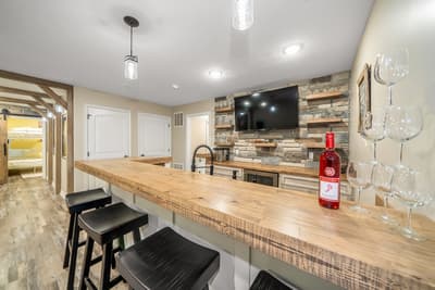 Your stylish bar area features warm wood countertops and cozy seating, perfect for evening drinks while watching your favorite shows.
