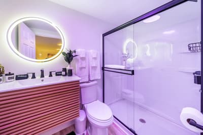 Step into your modern bathroom featuring an illuminated vanity mirror, sleek glass shower, and contemporary finishes for a luxurious daily routine.