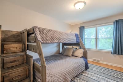 Cozy bunk beds await your family adventures, with soft quilted bedding and convenient stairs for easy access. Mattress Size: Twin Over Full