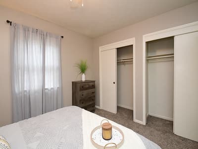 Unwind in your serene retreat with a plush bed, generous closet storage, and soft natural light filtering through sheer curtains—your perfect hideaway for restful mornings and peaceful nights.