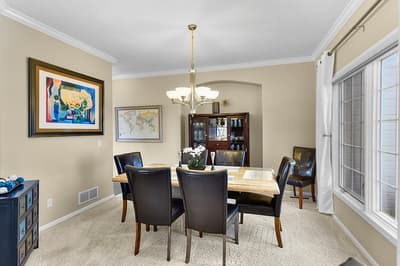 Gather around your elegant dining table for memorable meals in this sophisticated space with warm lighting and tasteful decor.