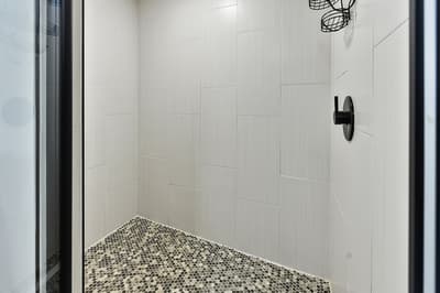 Step into your sleek walk-in shower with modern fixtures and stylish mosaic flooring for refreshing moments.