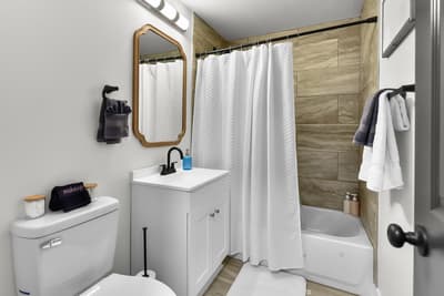 Your private bathroom features a sleek tub-shower combo, modern vanity, and thoughtful touches like fresh towels and good lighting for your comfort.