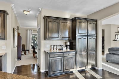 Step into your elegant kitchenette with rich wood cabinetry and marble countertops, perfect for brewing morning coffee.