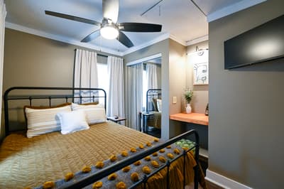 Your cozy bedroom combines modern comfort with charming details—drift off under the ceiling fan's gentle breeze in this stylish retreat.