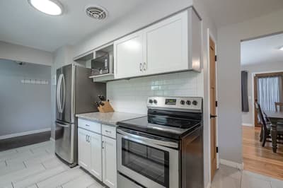 Your fully equipped kitchen features stainless steel appliances, granite countertops, and crisp white subway tile backsplash for effortless home cooking.