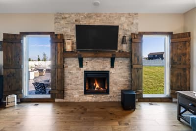 Warm up by your stunning stone fireplace while enjoying views of the patio and yard through rustic barn doors.