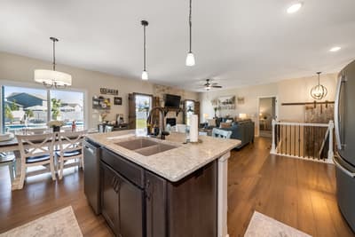 Your spacious kitchen island invites morning coffee and conversation while overlooking the sparkling pool beyond.