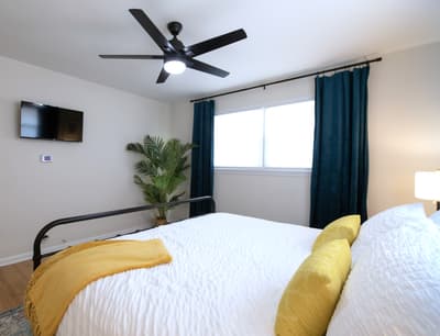 Sink into crisp white linens and let the ceiling fan keep you cool while you unwind with your favorite shows.