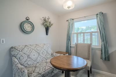 Relax in your cozy seating nook with vintage charm, where soft natural light filters through elegant curtains creating the perfect spot for morning coffee.