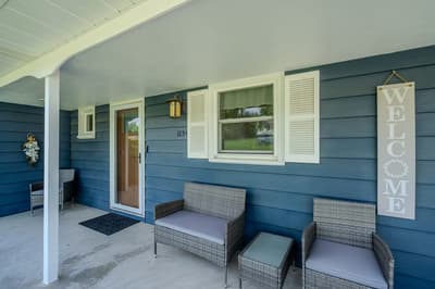 Relax on your private front porch with comfortable seating, perfect for morning coffee or evening conversations under the covered space.