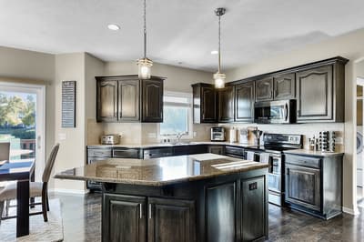 Cook memorable meals in this stunning kitchen featuring rich dark cabinetry, granite countertops, and modern appliances that make every culinary adventure effortless.