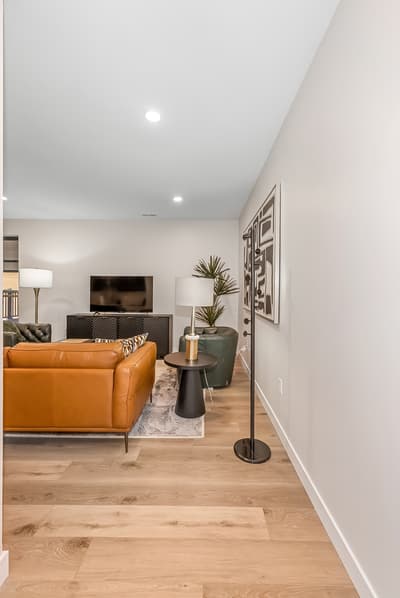 Sink into luxurious leather seating in your stylish living space, where warm wood floors and modern touches create the perfect retreat.
