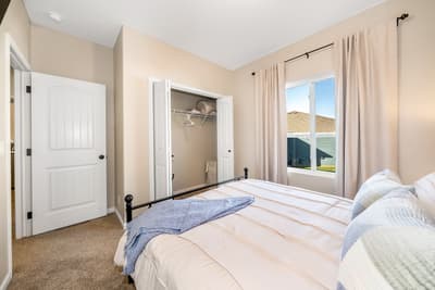 Rest peacefully in your bright bedroom with plush linens, walk-in closet storage, and warm natural light streaming through the windows.