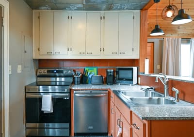 Your fully equipped kitchen features granite counters, stainless steel appliances, and warm pendant lighting for memorable meal preparation.