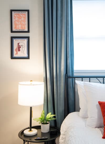Sink into crisp white linens in your thoughtfully designed bedroom, where curated art and soft lighting create the perfect ambiance for relaxation.