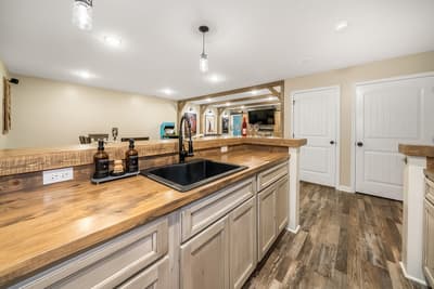 Step into your fully equipped kitchen featuring warm wood countertops, modern appliances, and rustic charm for memorable meal preparation.