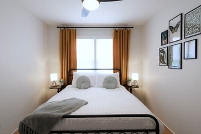 Sink into crisp linens and plush pillows in your serene bedroom sanctuary, where warm lighting and curated art create the perfect retreat.