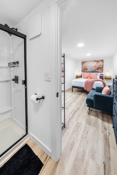 Your modern suite seamlessly blends comfort with style, featuring a sleek bathroom and cozy bedroom with plush seating.