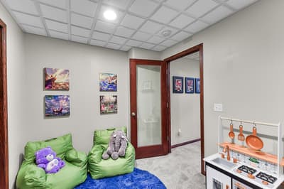 Your little ones will love this dedicated playroom with cozy bean bags, colorful artwork, and a toy kitchen for hours of imaginative fun.