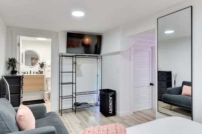 Relax in your stylish bedroom with cozy seating, organized storage, and a wall-mounted TV for entertainment.