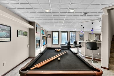 Your personal game room awaits with a full-sized pool table and bar seating for friendly competition and relaxation.