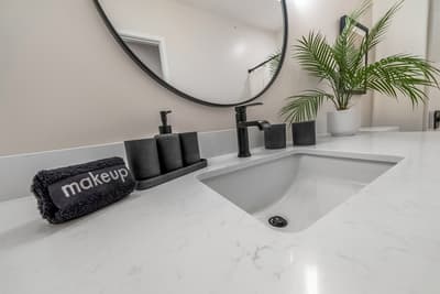 Your modern bathroom features a sleek white vanity with elegant black fixtures and thoughtful touches that make your daily routine feel luxurious.