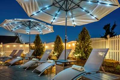 Unwind on your private patio under twinkling umbrella lights, where soft towels await and evening relaxation begins.