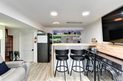 Your sleek kitchen and living space blend modern design with comfort, featuring a breakfast bar and entertainment area perfect for relaxing evenings.