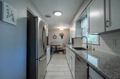Your modern galley kitchen features granite countertops, stainless appliances, and subway tile backsplash for effortless meal prep.