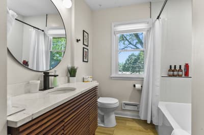 Step into your stylish bathroom featuring a sleek floating vanity, modern fixtures, and natural light streaming through large windows.